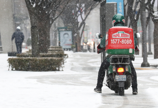 함박눈이 내린 서울 강남구 테헤란로 부근 도로에서 한 배달 직원이 조심스럽게 오토바이를 운행하고 있다. /연합뉴스