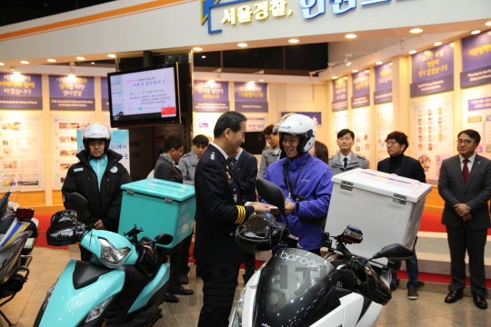 이주민(가운데) 서울지방경찰청장이 온오프라인연계(O2O) 배달대행업체 바로고 배달원에게 안전스티커를 나눠주고 있다. /사진제공=바로고