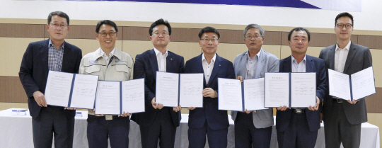 김명우(왼쪽 네번째) 두산중공업 사장이 지난해 6월 베트남 중꾸엇공단 두산비나에서 5개 협력사 대표이사들과 함께 베트남 진출을 위해 체결한 상호업무협약서를 들어보이고 있다./사진제공=두산중공업