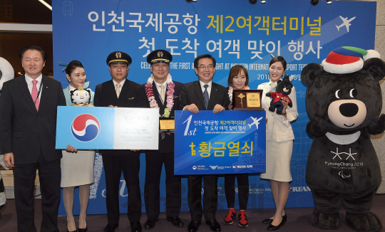 인천국제공항 제2여객터미널 공식 개장일인 18일 새벽 마닐라에서 대한항공(KE624편)을 타고 4시20분에 도착한 정유정 씨(왼쪽 여섯번째)와 최운식 기장(왼쪽 네번째)이 우기홍 대한항공 부사장(왼쪽)과 정일영 인천공항공사 사장(왼쪽 다섯번째)과 기념촬영을 하고 있다./영종도=이호재기자.