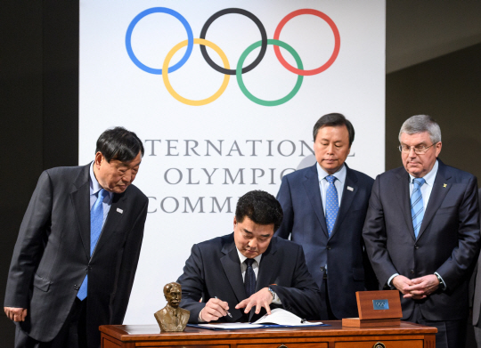 김일국(왼쪽 두 번째) 북한 체육상이 20일 IOC 평창올림픽 회의 뒤 협약서에 사인하고 있다. /로잔=AFP연합뉴스