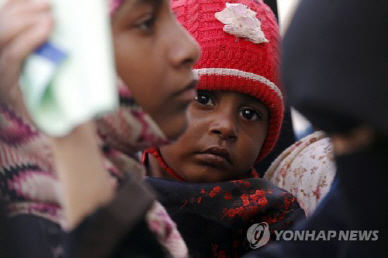 예멘 수도 사나에서 어린이를 안은 여성이 보건소 밖에서 진료 차례를 기다리는 모습/AFP=연합뉴스