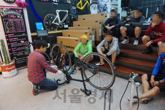 서울 소재의 트렉 컨셉스토어에서 전문가가 자전거 입문자를 대상으로 펑크난 타이어 교체 방법에 대해 설명하고 있다. /사진제공=트렉