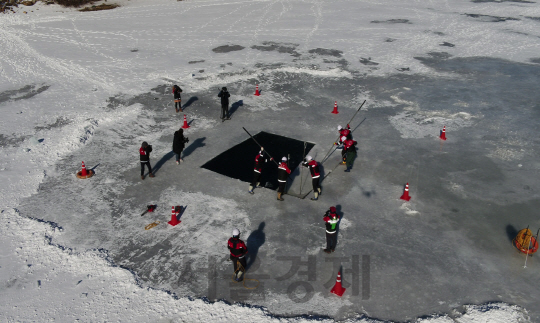 산불청 산불진화대원들이 결빙된 저수지에서 얼음구멍을 내는 작업을 하고 있다. 사진제공=산림청