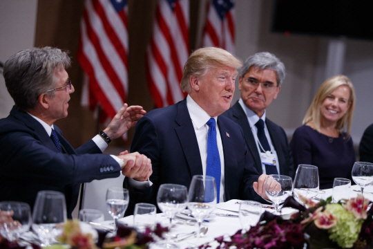 스위스 다보스에서 개최되고 있는 세계경제포럼(WEF)에 참석 중인 도널드 트럼프 미국 대통령(왼쪽 두 번째)이 25일 유럽비즈니스리더 만찬에서 흥겨운 표정으로 SAP 최고경영자(CEO) 빌 맥더모트(왼쪽)의 손을 잡고 있다. 이날 트럼프 대통령은 “달러는 점점 더 강해질 것”이라고 말했다. /AP연합뉴스