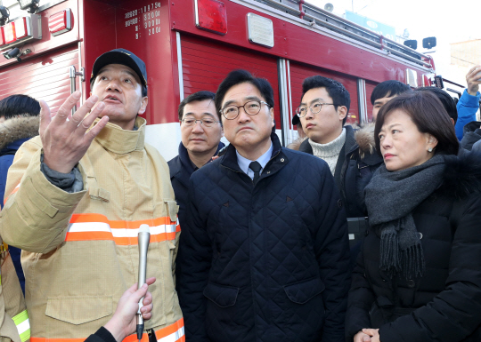 우원식 더불어민주당 원내대표가 26일 오후경남 밀양시 가곡동 세종병원 화재현장을 찾아 소방 관계자의 브리핑을 듣고 있다./연합뉴스