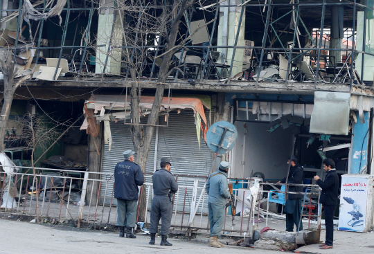 27일(현지시간) 아프가니스탄 경찰들이 수도 카불에서 폭탄 테러로 크게 파손된 사건 현장 주변 건물을 조사하고 있다./카불=로이터연합뉴스