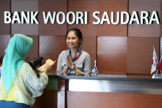 우리은행이 지난 2014년 인도네시아에 설립한 ‘우리소다라뱅크’ 현지 지점에서 창구 직원이 손님을 맞고 있다.    /사진제공=우리은행