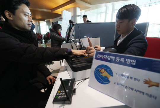 손바닥 정맥·지문 등 생체인식 신원확인 서비스가 처음으로 시행된 29일 김포공항 생체정보 등록대가 이용자들로 붐비고 있다. 한국공항공사는 ‘신분증이 필요없는’ 생체인식 서비스를 이날부터 김포공항·제주공항 사이 국내선에 적용했으며 올해 안으로 김해·대구·청주공항 등으로도 확대할 예정이다.  /연합뉴스