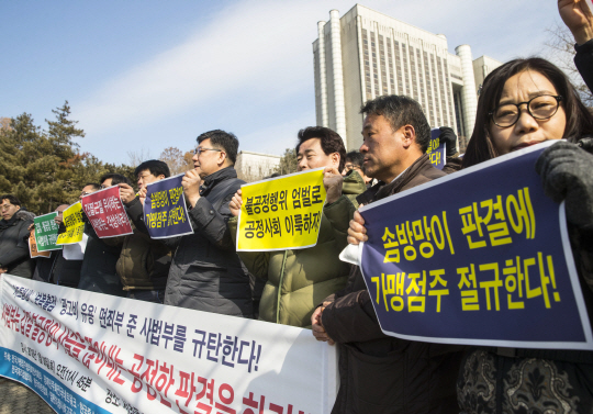 전국가맹점주협의회 관계자들이 30일 서울 서초구 법원삼거리 앞에서 ‘미스터피자 갑질 봐주기 판결 규탄 기자회견’를 열고 정우현 전 미스터피자 회장에 대한 1심 선고(징역 3년·집행유예 4년)를 규탄하는 구호를 외치고 있다. /연합뉴스