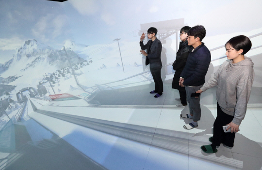 방문객들이 31일 강릉 올림픽파크에 마련된 5G 홍보관의 ‘텔레포트(Teleport)’ 공간에서 입체영상으로 스키점프대에 서 있는 듯한 체험을 하고 있다. /사진제공=KT
