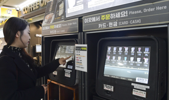 31일 서울 강남역 인근 커피전문점 입구에서 고객이 무인 자판기를 이용해 음료를 주문하고 있다. /송은석기자