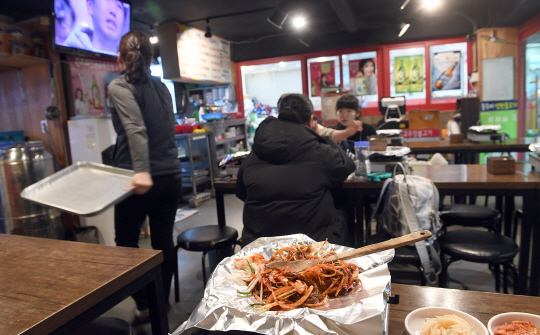 최저임금 인상 시행으로 자영업자들이 운영하는 식당을 중심으로 고용절벽이 이어지고 있는 31일 서울 홍익대 인근의 한 불고기 전문식당에서 주인이 혼자 음식을 조리하며 테이블을 정리하고 있다./이호재기자.