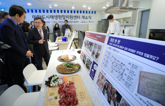 31일 서울 성동구 마장축산물시장 내 건물에 마련된 ‘마장키친’에서 마장도시재생 현장지원센터 개소식 참석자들이 요리 재료를 살펴보고 있다. /연합뉴스