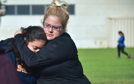 1일(현지시간) 총격 사건이 발생한 미국 캘리포니아 주 로스앤젤러스(LA)의 살바도르 카스트로 중학교에서 생사를 확인한 모녀가 포옹을 하고 있다. /LA=AFP연합뉴스