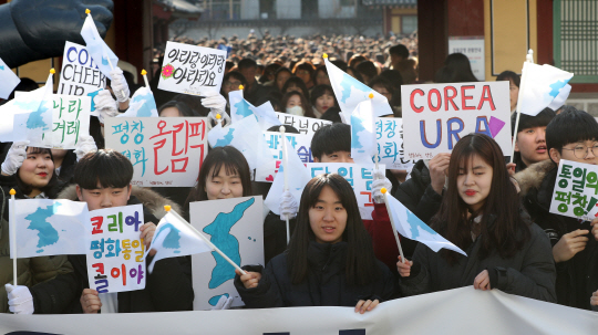 2일 강원도 원주에서 열린 ‘평창동계올림픽 남북공동응원단 출범 기자회견’에서 참석자들이 응원구호가 적힌 손팻말과 한반도기를 흔들며 환호하고 있다. /연합뉴스