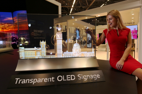 LG전자가 6일(현지시간) 네덜란드 암스테르담에서 열리는 상업용 디스플레이 전시회 ‘ISE 2018’에 전시한 차세대 55인치 투명 올레드 사이니지를 회사 측 모델이 소개하고 있다./사진제공=LG전자