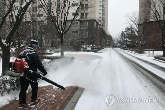 서울의 한 아파트 단지에서 경비원이 제설작업을 하는 모습/연합뉴스