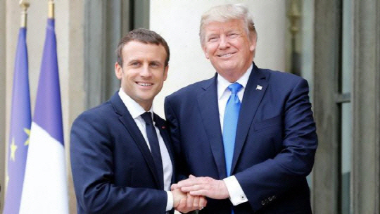 두 손을 맞잡고 있는 도널드 트럼프(오른쪽) 미국 대통령과 에마뉘엘 마크롱 프랑스 대통령. /게티이미지