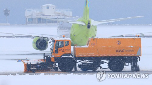 8일 오전 한국공항공사 제설차량이 제주공항 활주로의 눈을 치우고 있다./연합뉴스