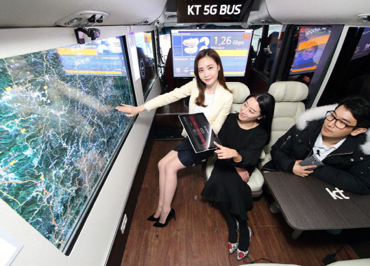 KT 직원들이 ‘5G 버스’ 안에서 5G 테스트 네트워크를 통해 데이터 전송 시연을 하고 있다.
