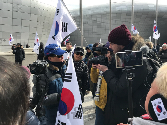 11일 오후 2시 서울시 동대문디자인플라자 앞 태극기집회에서 미국 인터넷언론사 ‘버즈피드’의 라이언 브로드릭 기자가 집회 참가자를 인터뷰하고 있다. /손구민 기자