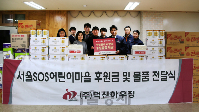 덕신하우징 임직원들이 9일 서울 신월동 SOS어린이마을을 방문해 생활용품과 기부금을 전달하고 기념사진을 찍고 있다. /사진제공=덕신하우징