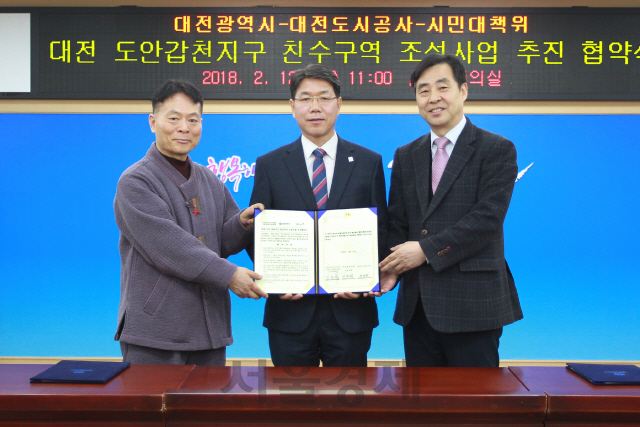 이재관(사진 왼쪽에서 두번째) 대전시장 권한대행과 유영균(〃세번째) 대전도시공사 사장, 김규복(〃첫번째) 시민대책위원장이 ‘대전 도안 갑천친수구역 조성사업’ 협약을 체결하고 있다. 사진제공=대전시