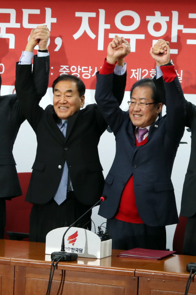 이재오(왼쪽) 늘푸른한국당 대표가 12일 여의도 자유한국당사에서 열린 입당식에서 홍준표 대표와 손을 들어보이고 있다./연합뉴스