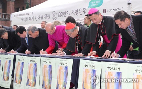 염수정 추기경(왼쪽 다섯번째)이 작년 12월 3일 오후 서울 명동성당에서 열린 ‘낙태죄 폐지 반대를 위한 100만인 서명운동’에 참석해 서명하고 있다./ 연합뉴스