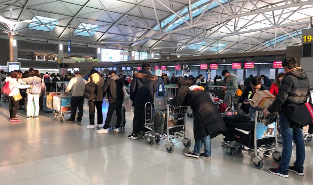 설 명절 연휴를 하루 앞둔 14일 인천공항 제1터미널 출국장의 항공사 카운터에 출국 수속을 밟기 위해 승객들이 긴 줄을 서 있다. /사진=연합뉴스