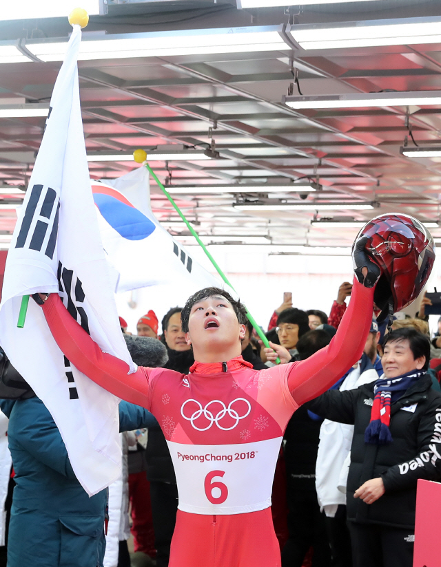 윤성빈이 16일 한국 썰매 사상 첫 올림픽 금메달을 따낸 뒤 태극기를 들고 감격해하고 있다. /연합뉴스