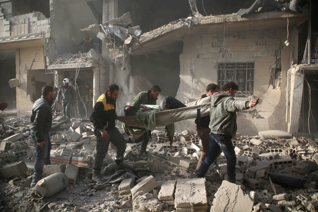 시리아 민방위(하얀헬멧) 대원들이 지난 8일(현지시간) 동쪽 구타 아르빈에서 부상자를 들것에 싣고 이동하고 있다. /구타=AFP연합뉴스