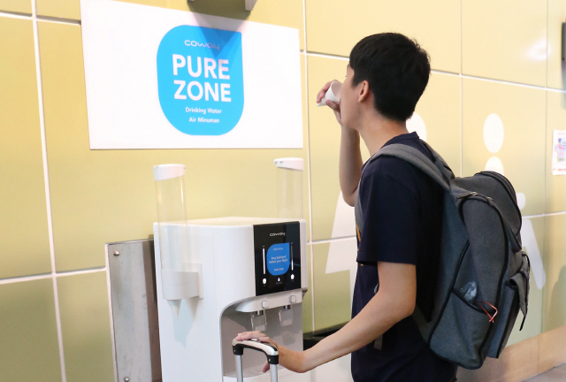 말레이시아 쿠알라룸푸르국제공항(Kuala Lumpur International Airport) 내 코웨이 정수기를 체험할 수 있는 ‘Pure Zone’에서 공항 이용객이 코웨이 정수기로 정수한 깨끗한 물을 마시고 있다./사진제공=코웨이