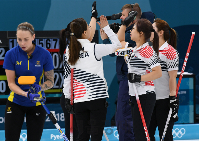 여자 컬링 대표팀이 19일 평창동계올림픽 예선 6차전에서 강호 스웨덴을 꺾은 뒤 기쁨을 나누고 있다. /강릉=권욱기자