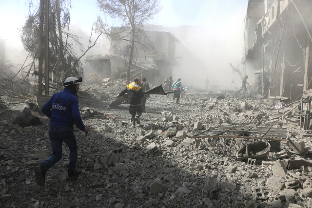 시리아 민방위대 ‘하얀헬멧’ 대원들이 20일(현지시간) 시리아 정부군의 공습을 받은 현장에서 구조작업을 펼치고 있다. /다마스쿠스=AP연합뉴스