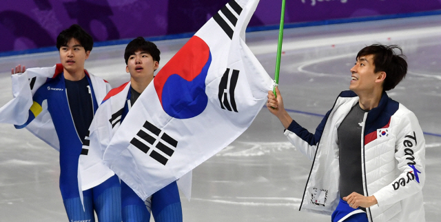 빙속 남자 팀추월 대표팀의 김민석(왼쪽부터)과 정재원, 이승훈이 21일 평창올림픽 은메달을 따낸 뒤 태극기를 들고 링크를 돌며 관중에게 인사하고 있다. /강릉=권욱기자