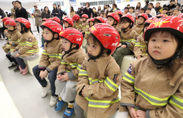 22일 서울 동대문구 동대문디자인플라자에서 열린 제7회 어린이 안전짱 체험박람회에 참가한 어린이들이 소방관으로부터 화재 및 지진에 따른 대피 방법을 듣고 있다. 이 박람회는 24일까지 열린다.  /연합뉴스