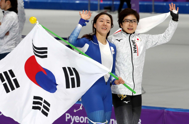 이상화(왼쪽)와 일본의 고다이라 나오가 18일 빙속 500m 경기 후 함께 인사하고 있다. 올림픽 3연패에 도전한 이상화는 ‘라이벌 대결’에서 은메달을 목에 걸었다.