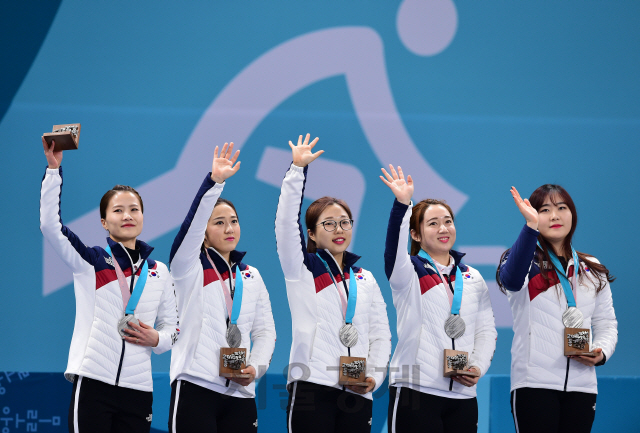 평창동계올림픽에서 은메달을 딴 대한민국 여자 컬링 대표팀이 25일 시상대에서 손을 흔들고 있다. /강릉=권욱기자