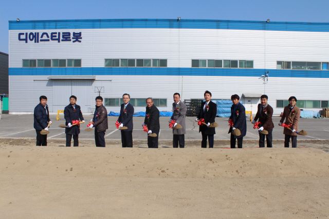 22일 충청북도 천안에서 열린 디에스티로봇 공장 착공식에서 최명규(왼쪽 여섯번째) 대표가 내외빈과 함께 첫 삽을 뜨고 있다. /사진제공=디에스티로봇