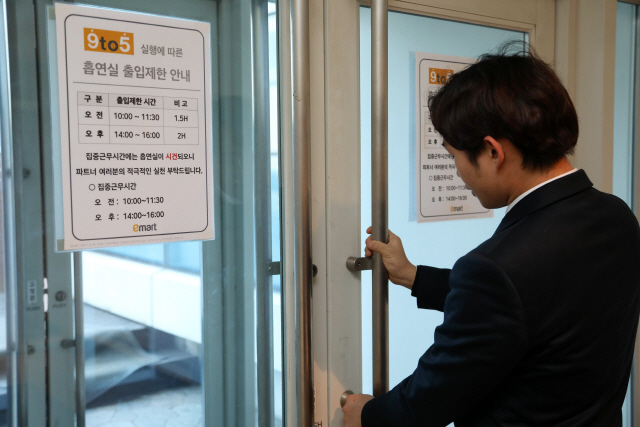 서울 성수동 이마트 본사에서 한 직원이 오전 10시 집중근무시간을 맞아 흡연실 문을 잠그고 있다. /사진제공=이마트