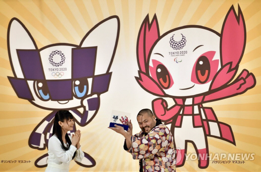 28일 일본 도쿄의 호요노모리 가쿠엔 학교에서 2020 도쿄올림픽 공식 마스코트를 디자인한 다니구치 료(오른쪽)가 마스코트의 3D 모델을 들고 환하게 웃고 있다./EPA=연합뉴스