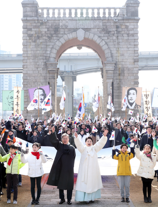 문재인 대통령과 부인 김정숙 여사가 1일 오전 제99주년 3ㆍ1절을 맞아 서울 서대문형무소 역사관에서 독립문까지 대형 태극기를 들고 행진한 뒤 만세 삼창을 하고 있다. /연합뉴스