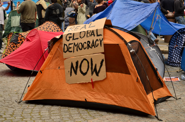 2011년 월스트리트 점거 시위 당시 한 시위자가 텐트 위에 ‘지금 전 지구적인 진짜 민주주의를!’ 이라고 적은 팻말을 붙여놨다. /사진제공=위키피디아
