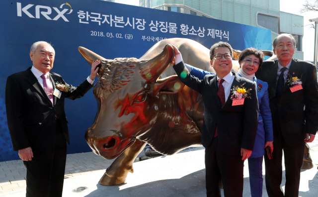 한국거래소는 증권시장 개장 62주년을 맞아 2일 부산국제금융센터에 황소상을 설치했다. 이 날 제막식에 참석한  정지원(가운데) 한국거래소 이사장과 관계자들이 황소상 뿔을 만지며 기념촬영을 하고 있다. /부산=연합뉴스