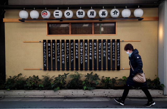 일본 도쿄의 한 상점 앞을 지나치는 시민. /AFP연합뉴스