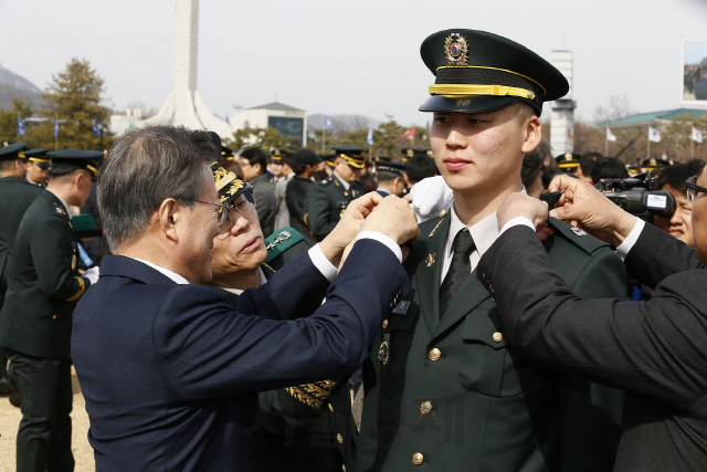 6일 서울 공릉동 육군사관학교에서 열린 생도 74기 졸업 및 임관식에서 문재인 대통령이 임관장교에게 계급장을 달아주고 있다.