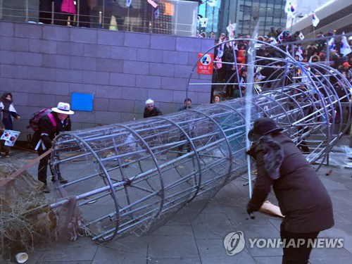 보수단체 태극기집회 참가자들이 1일 오후 서울 종로구 광화문역 해치마당에서 촛불 조형물을 끌어내려 파손하고 있다./연합뉴스