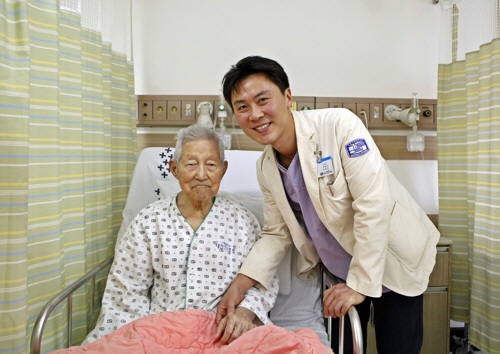 박하욱(오른쪽) 가톨릭대 대전성모병원 교수가 106세 급성 심근경색 수술 환자의 손을 잡고 있다. 이 환자는 고난도의 수술을 받고 건강을 회복했다. /사진제공=대전성모병원